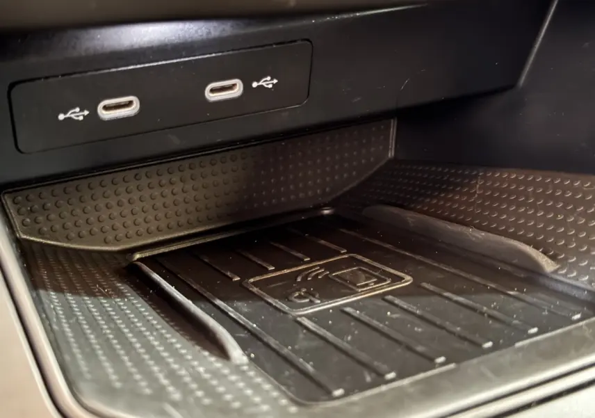 Gros plan sur la zone de recharge sans fil et ports USB dans l'habitacle noir de la SEAT IBIZA 2024.