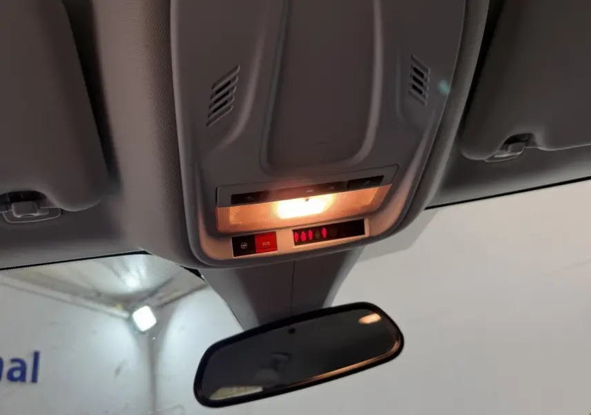 Plafonnier intérieur allumé avec bouton SOS et rétroviseur central dans un Opel Grandland X noir, vue de l'avant cabine.