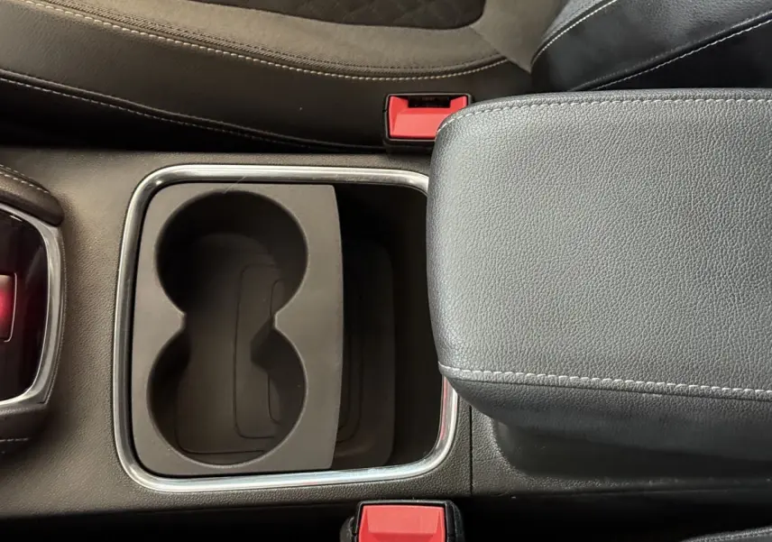 Gros plan sur la console centrale noire de l'Opel Grandland X 2021 avec porte-gobelets et accoudoir cuir.