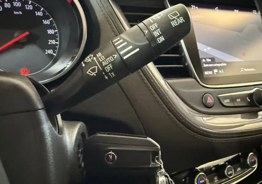Détail intérieur du tableau de bord de l’Opel Grandland X 2021, avec commandes essuie-glaces et écran tactile de navigation.