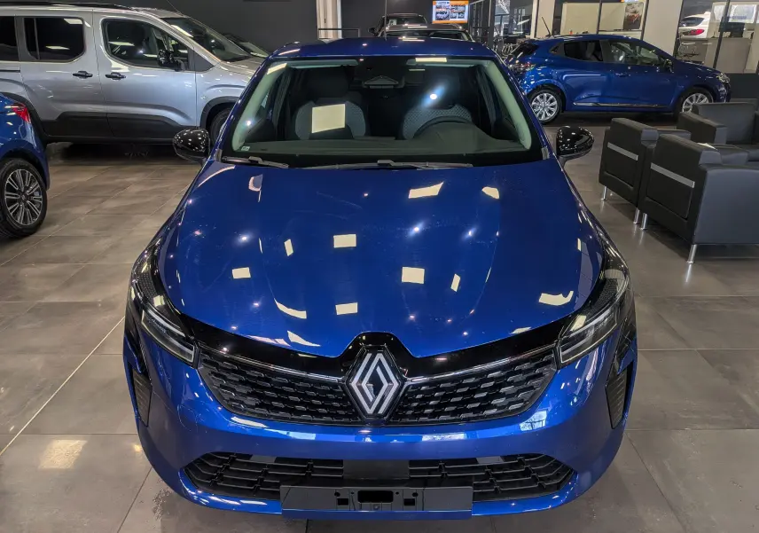 Vue avant d'une Renault Clio V Bleu Iron 2025, mettant en valeur sa calandre noire et ses phares LED fins.
