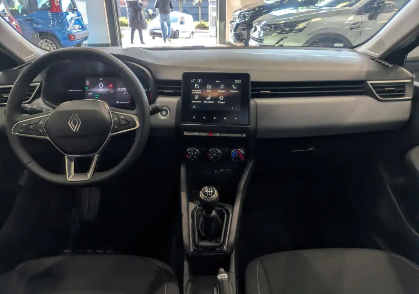 Vue intérieure avant de la Renault Clio V Blue dCi 100, tableau de bord noir avec écran tactile et volant multifonction.