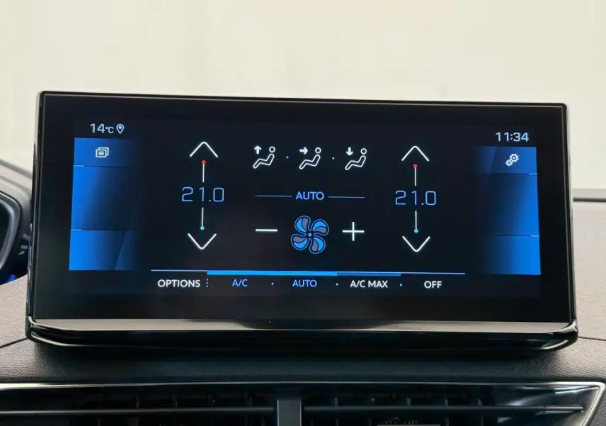 Écran tactile central affichant la climatisation bi-zone à 21°C dans un Peugeot 3008 gris foncé, vue intérieure frontale.