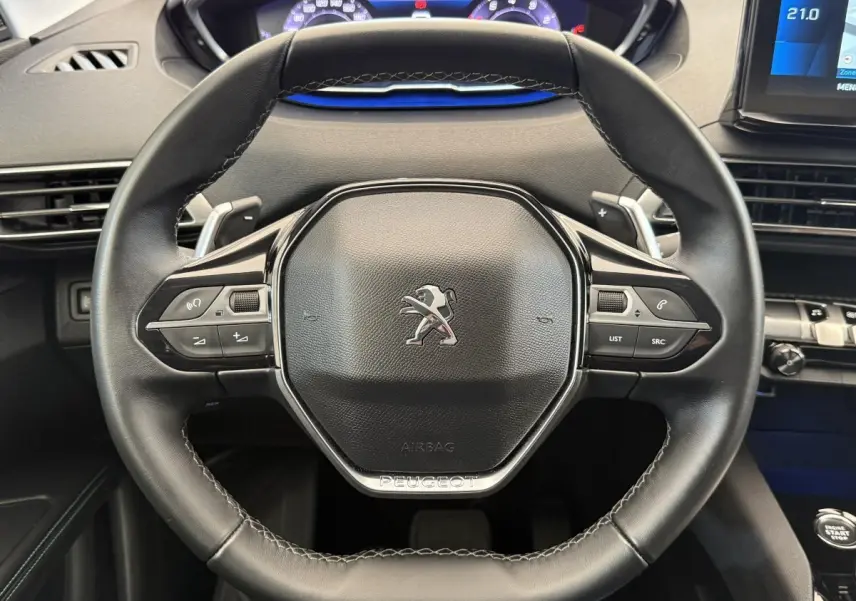 Vue rapprochée du volant cuir noir du Peugeot 3008 2022 avec commandes multifonctions et tableau de bord digital.