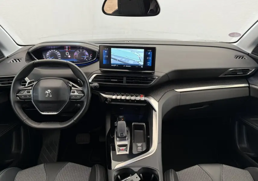Vue intérieure avant du Peugeot 3008 gris foncé, tableau de bord avec écran tactile et volant cuir multifonctions.