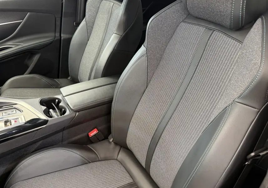 Gros plan sur les sièges avant gris cuir et tissu du Peugeot 3008 PureTech 130 Allure avec console centrale et accoudoir.