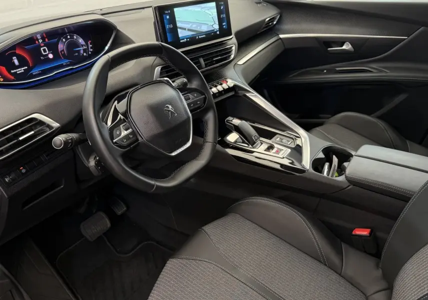 Intérieur avant droit du Peugeot 3008 gris foncé 2022, volant cuir, écran tactile et tableau de bord numérique.