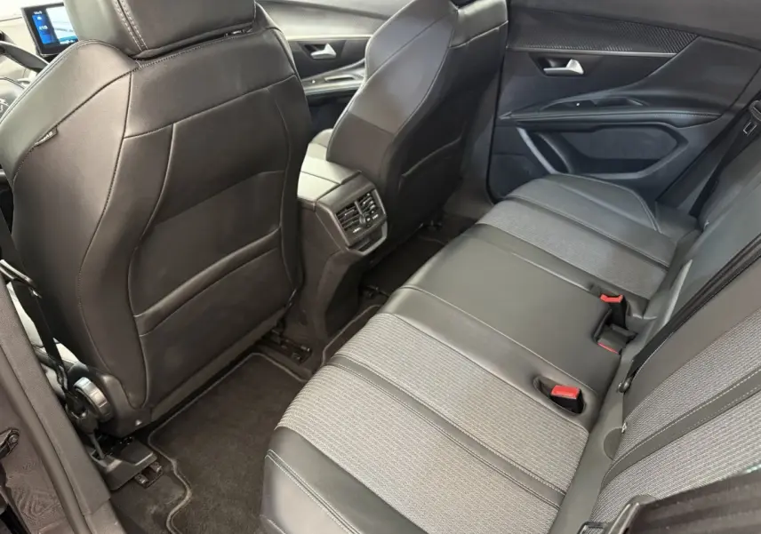 Vue intérieure arrière côté droit du Peugeot 3008 2022, sièges en cuir et tissu gris foncé avec aérateurs centraux.