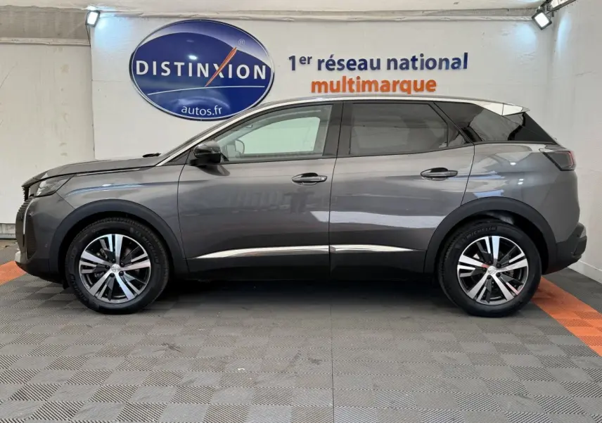 Vue latérale droite d'un Peugeot 3008 gris foncé 2022 dans un showroom avec logo Distinxion en arrière-plan.