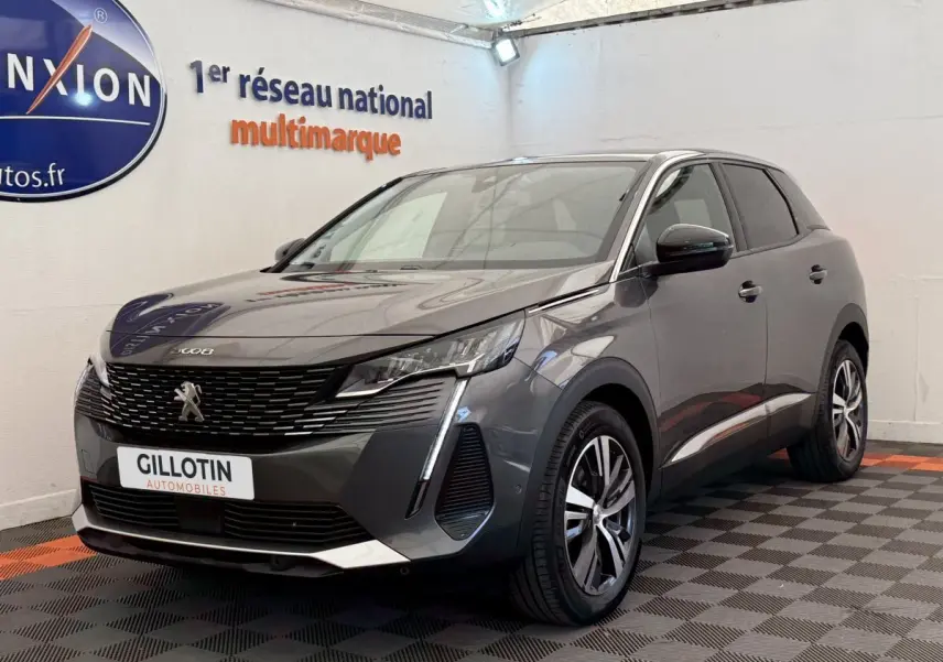 Peugeot 3008 gris foncé en 3/4 avant droit, avec calandre noire et feux LED distinctifs, en intérieur showroom.