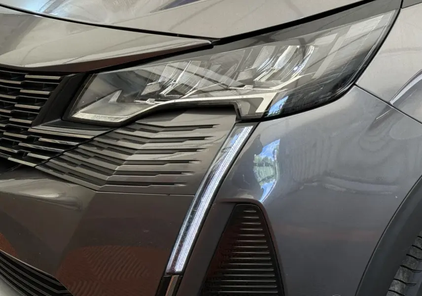 Gros plan sur le phare avant droit gris foncé du Peugeot 3008 avec signature lumineuse verticale LED distinctive.