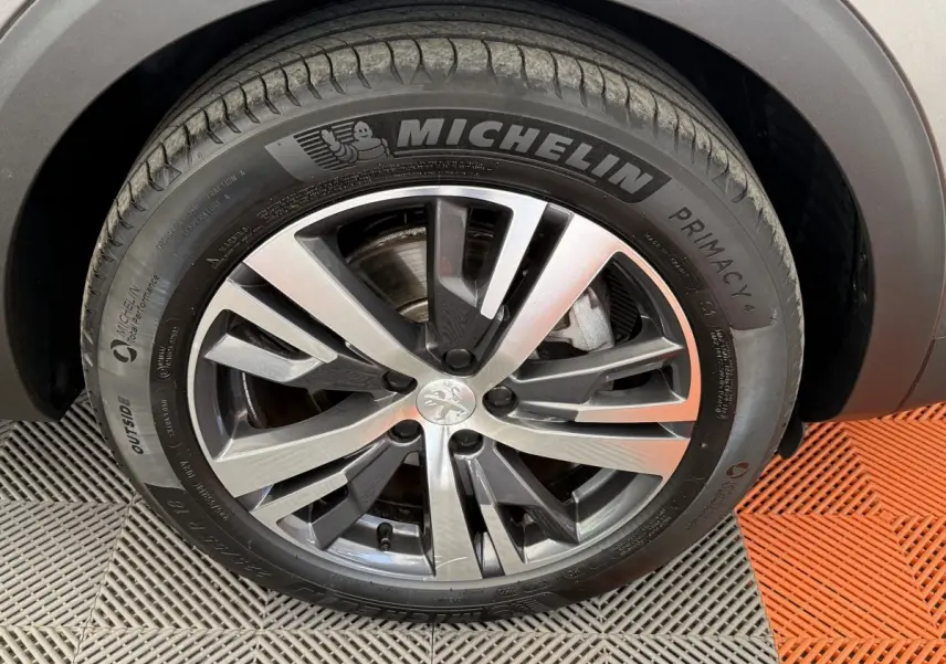 Gros plan sur la roue avant droite du Peugeot 3008 gris foncé, avec jante alliage et pneu Michelin Primacy 4.
