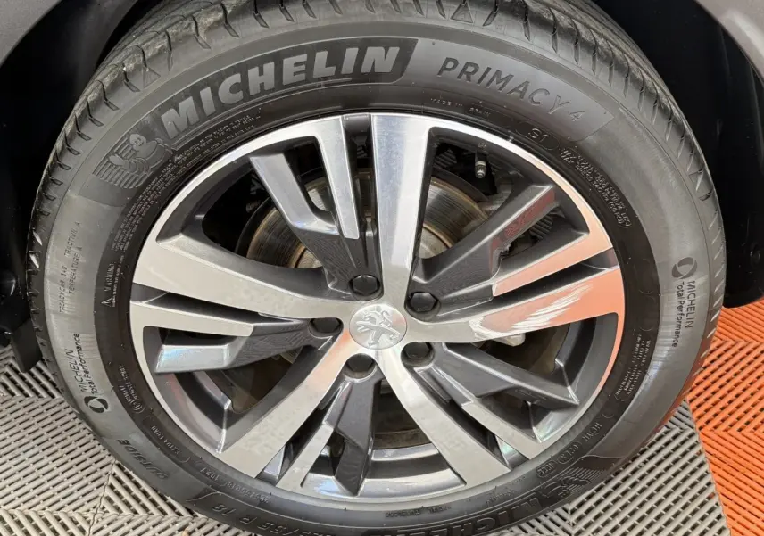 Gros plan sur la jante alliage gris foncé et le pneu Michelin d’un Peugeot 3008 PureTech 130 Allure.