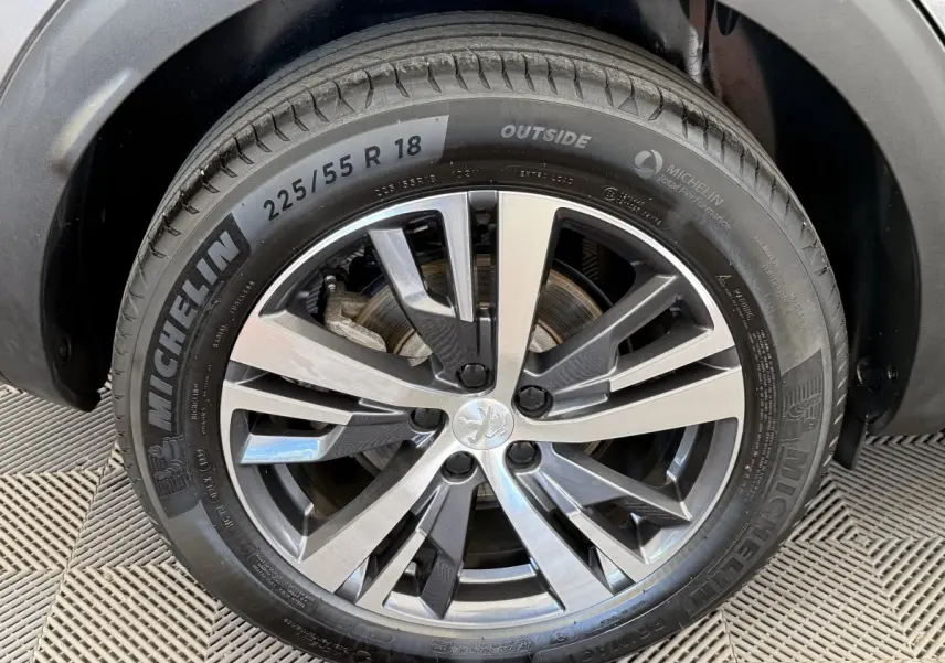 Gros plan sur la roue avant droite du Peugeot 3008 gris foncé avec jante alliage et pneu Michelin 18 pouces.