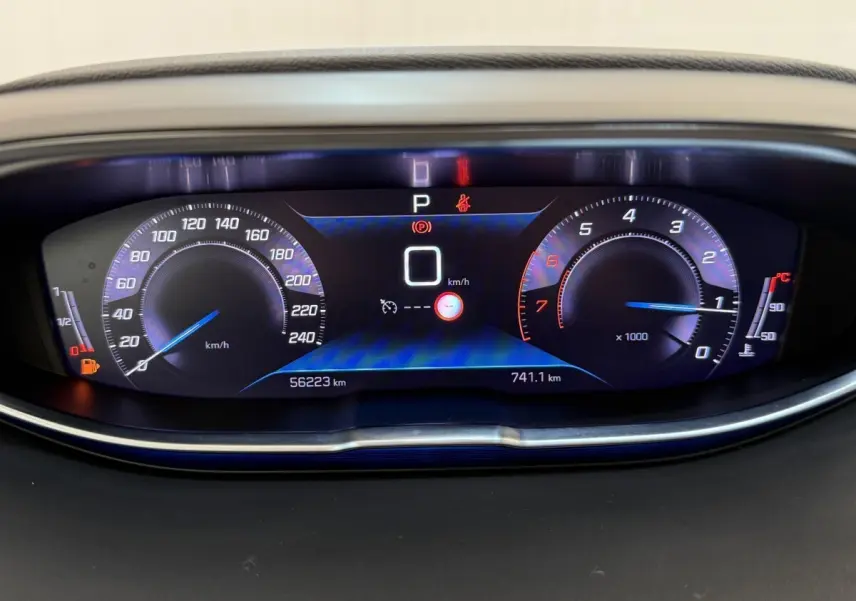 Vue rapprochée du tableau de bord numérique du Peugeot 3008 gris foncé, affichant la vitesse à 0 km/h et le compte-tours.