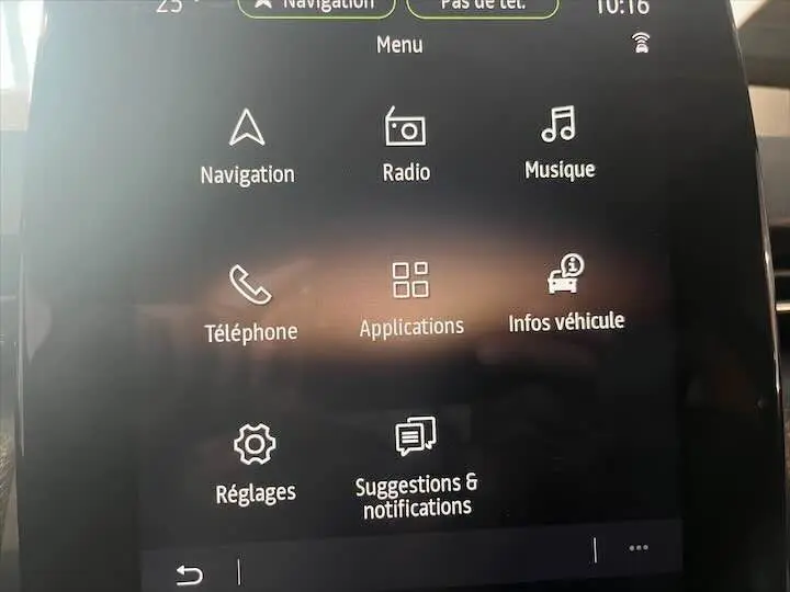 Écran tactile central de la Renault Clio V affichant le menu principal avec navigation, radio et téléphone.