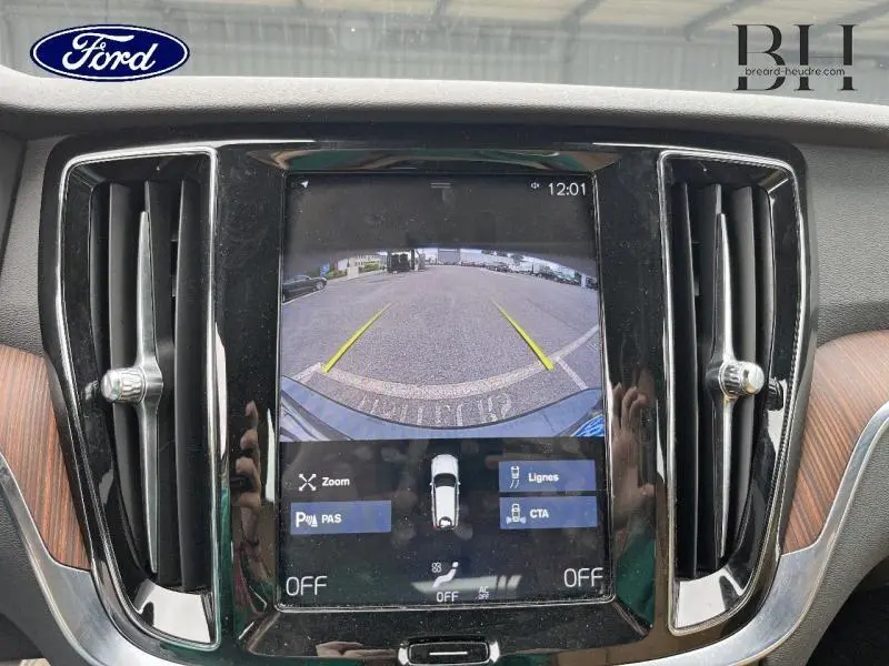 Écran central montrant la caméra de recul du Volvo V60 gris Savile, avec lignes de guidage jaunes visibles.