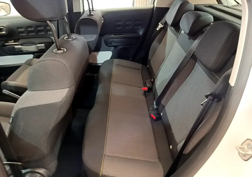 Vue intérieure côté droit montrant la banquette arrière grise et noire de la Citroën C3 blanche 2019.