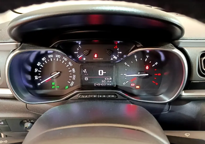 Vue rapprochée du tableau de bord de la Citroën C3 blanche de 2019, affichant le compteur et les voyants allumés.