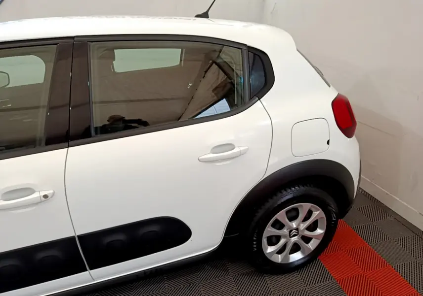 Vue côté droit arrière d'une Citroën C3 blanche avec protections latérales noires et jantes alliage.
