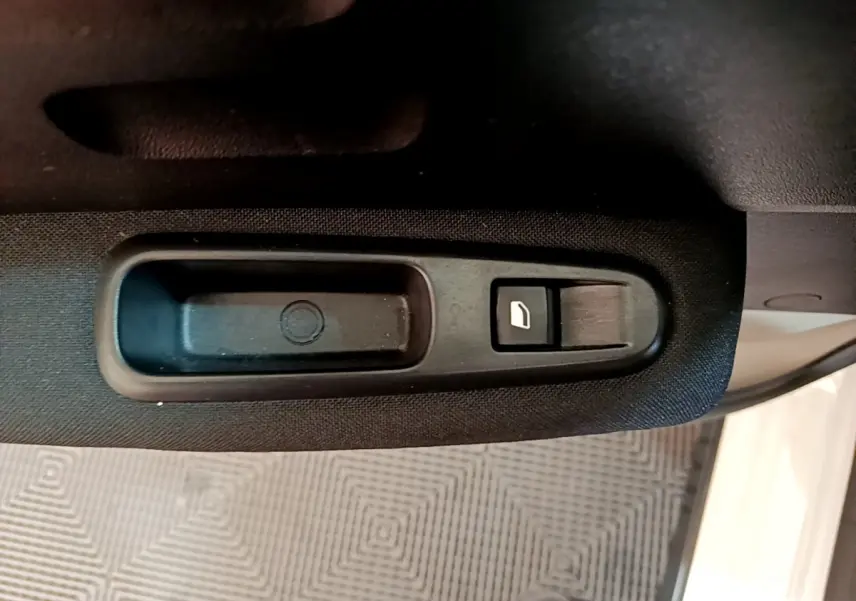 Bouton de commande de lève-vitre côté conducteur sur porte intérieure noire d'une Citroën C3 blanche 2019.