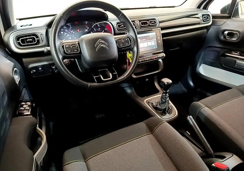 Intérieur avant de la Citroën C3 blanche 2019, volant cuir, écran tactile 7 pouces et boîte manuelle visible.