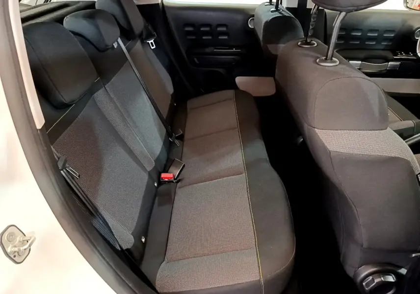 Vue intérieure côté gauche sur la banquette arrière noire et grise de la Citroën C3 blanche de 2019 avec appuie-têtes.
