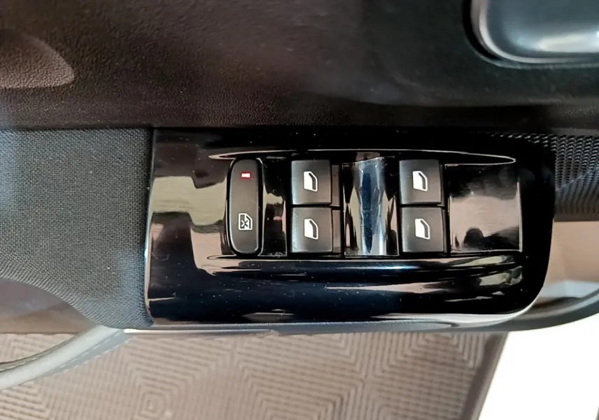 Gros plan sur les commandes de lève-vitres électriques côté conducteur d'une Citroën C3 blanche, finition Shine Business.