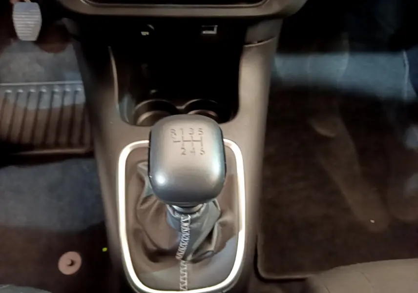 Le levier de vitesses manuel noir de la Citroën C3 PureTech 110 vue de dessus, entouré d'un cadre argenté.