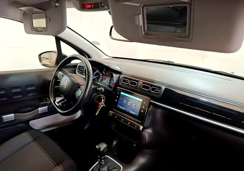 Vue intérieure côté conducteur de la Citroën C3 blanche 2019 avec tableau de bord moderne et écran tactile central.