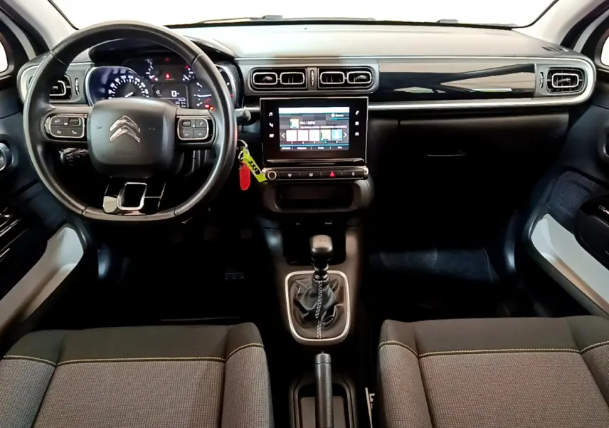 Intérieur de la Citroën C3 2019 vue de face, tableau de bord noir avec écran tactile central et volant cuir multifonctions.