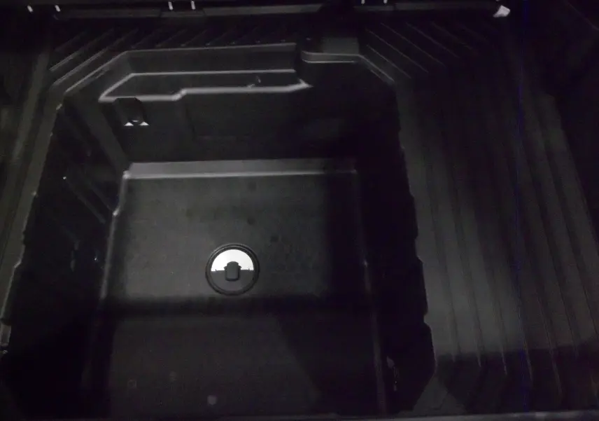 Coffre vide en plastique noir du Ford Puma 2025 gris Cactus, vue plongeante sur l'espace de rangement.