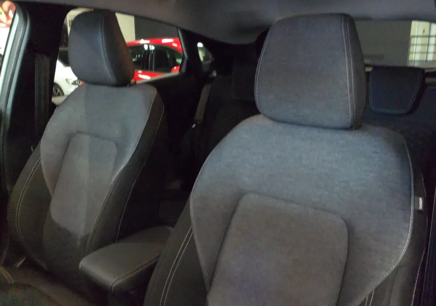 Gros plan sur les sièges avant en tissu gris du Ford Puma 2025, version Titanium, dans un intérieur sombre.