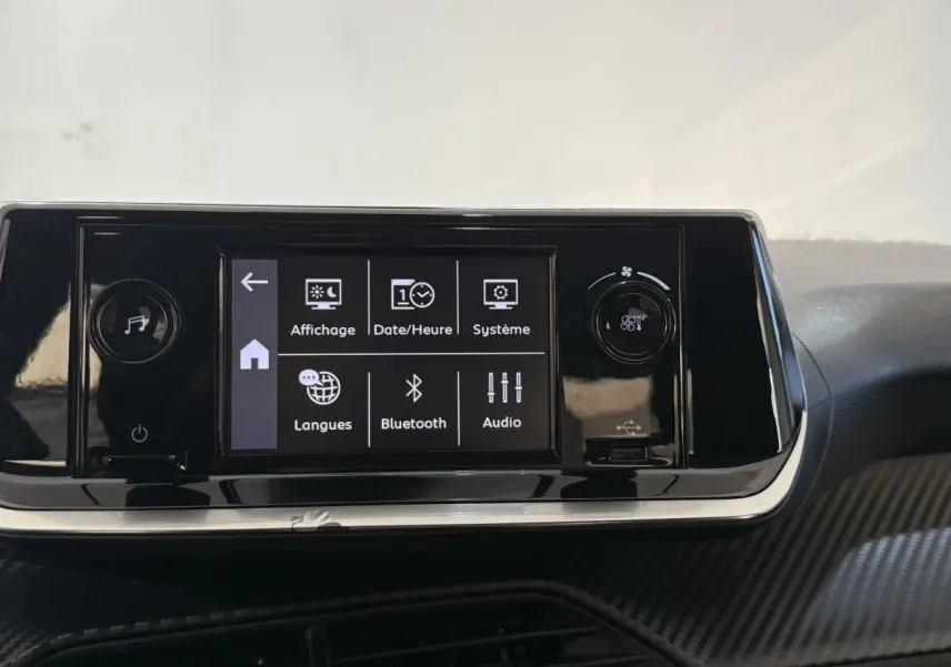 Écran tactile central de la Peugeot 208 PureTech 75 S&S Like 2020 avec menu affichage et Bluetooth, tableau de bord noir.