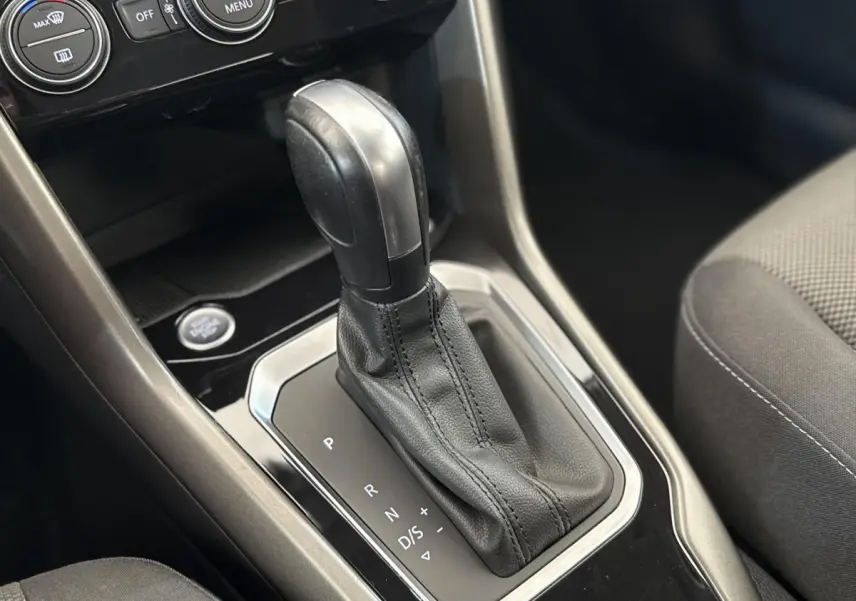 Le levier de vitesses automatique noir et argenté du Volkswagen T-Roc 2.0 TDI, vue rapprochée de l'intérieur.