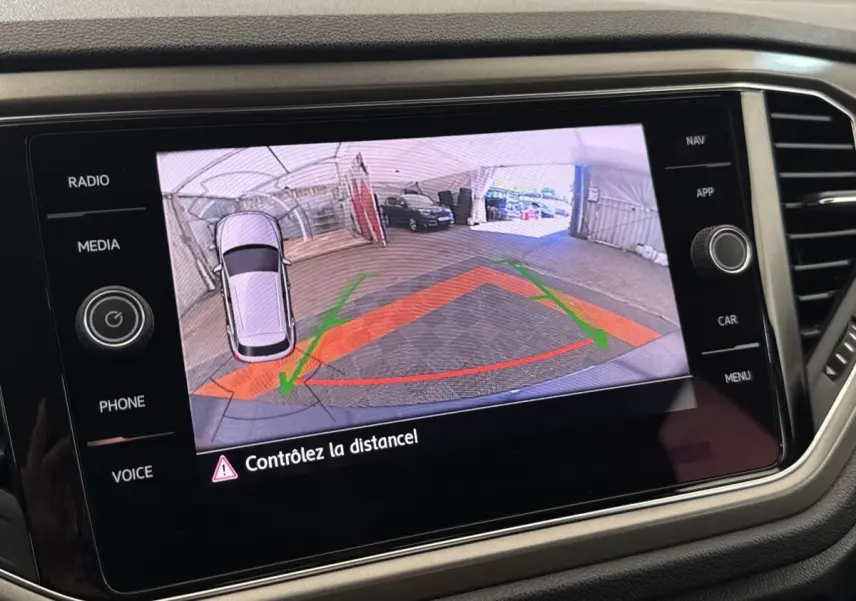 Écran tactile intérieur affichant la caméra de recul du Volkswagen T-Roc bleu avec guidage de trajectoire coloré.