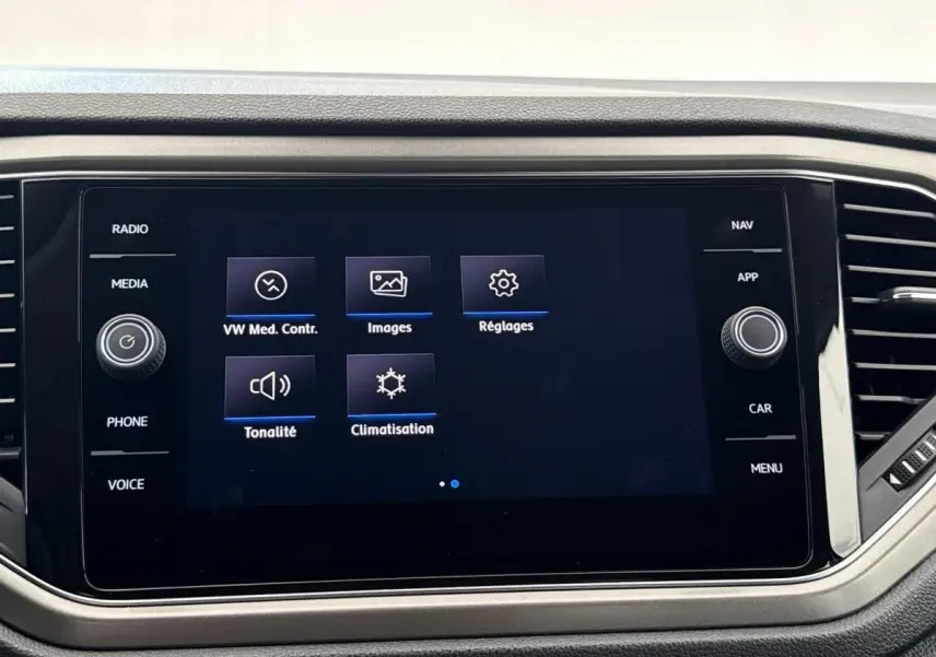 Écran tactile central du tableau de bord du Volkswagen T-Roc 2.0 TDI bleu, affichant les options média et climatisation.