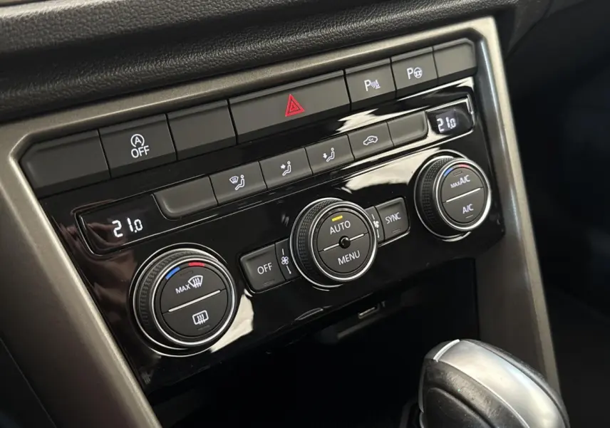 Gros plan sur la console centrale du Volkswagen T-Roc 2020, avec commandes de climatisation et levier de boîte automatique.