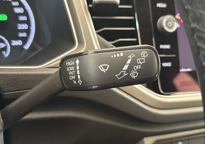Gros plan sur la manette d’essuie-glace côté droit du tableau de bord du Volkswagen T-Roc bleu 2020.