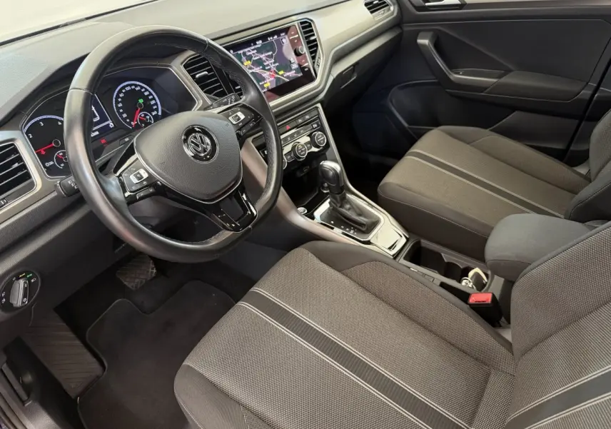Vue intérieure côté conducteur du Volkswagen T-Roc 2.0 TDI 150, montrant le volant cuir et l’écran tactile central.