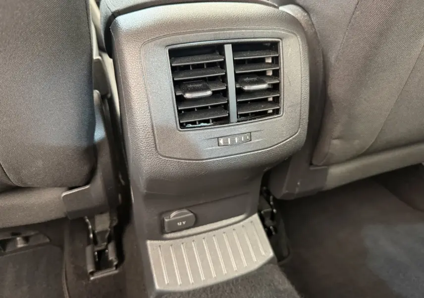 Vue rapprochée des aérateurs arrière et prise 12V entre les sièges noirs du Volkswagen T-Roc 2020.