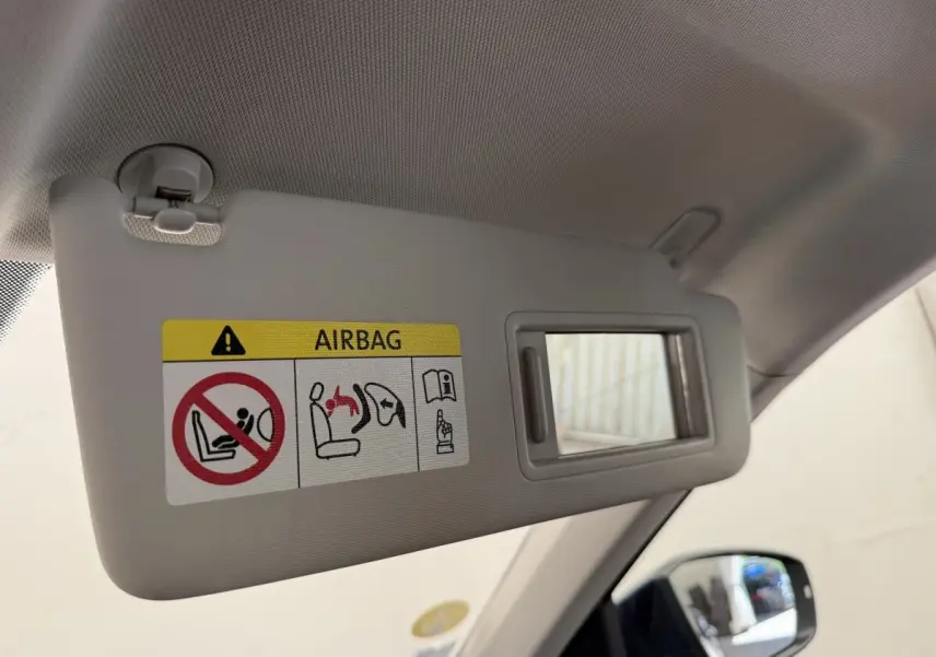 Détail du pare-soleil côté conducteur avec miroir et avertissement airbag dans un Volkswagen T-Roc bleu 2020.