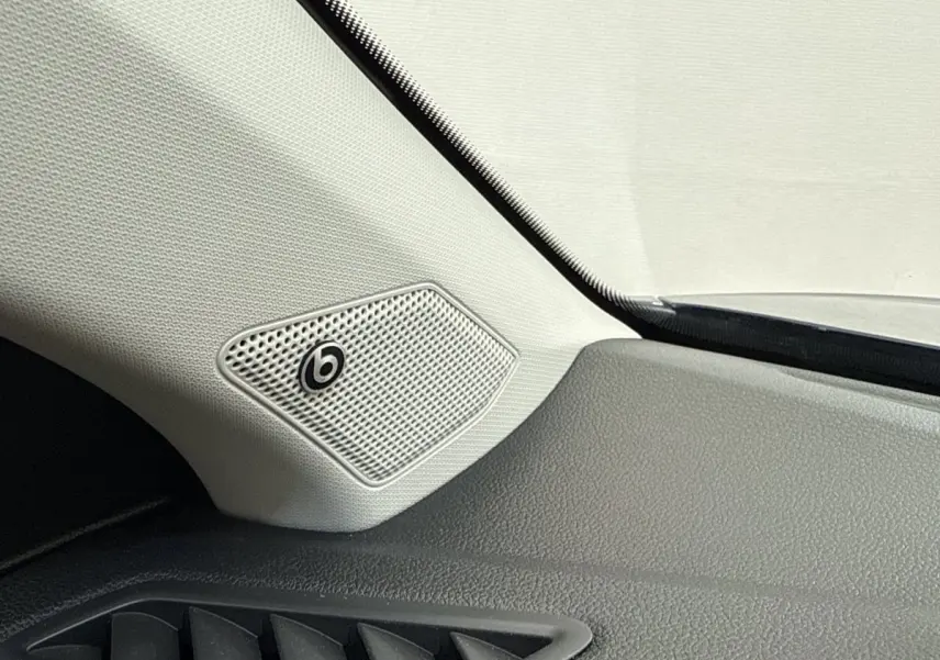 Gros plan sur l'enceinte Beats intégrée côté gauche du tableau de bord du Volkswagen T-Roc bleu 2020.