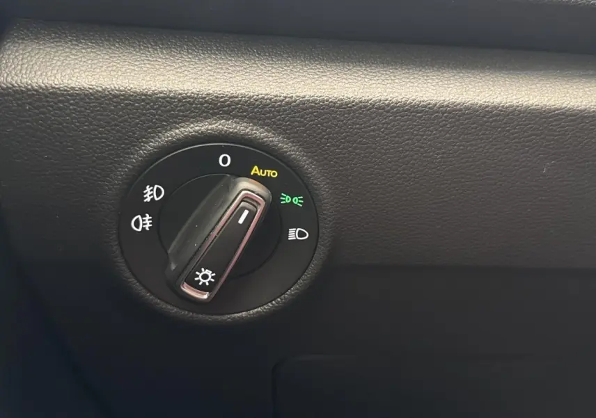 Gros plan sur la molette de commande des phares du Volkswagen T-Roc 2.0 TDI bleu, affichage des options d’éclairage.