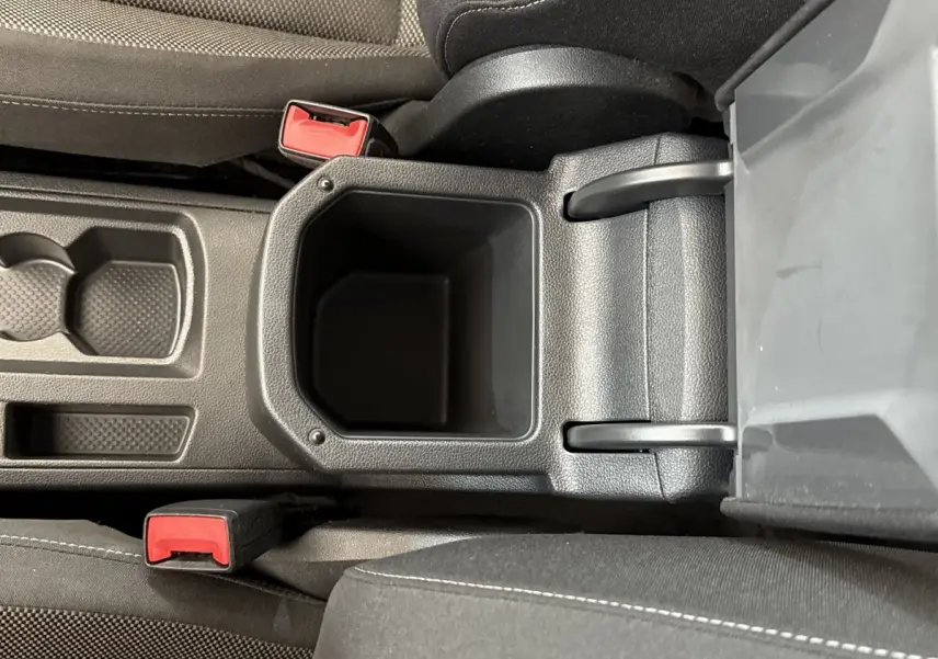 Vue plongeante sur le rangement central noir entre les sièges avant du Volkswagen T-Roc 2.0 TDI 150 bleu de 2020.