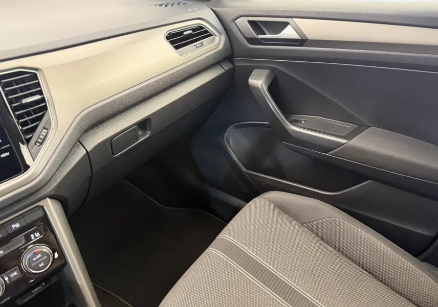 Vue intérieure côté passager du Volkswagen T-Roc 2020, mettant en valeur la sellerie grise et le tableau de bord noir.