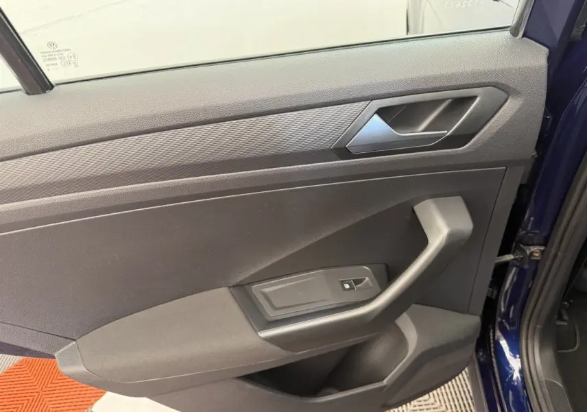 Vue rapprochée de la porte avant droite bleu foncé du Volkswagen T-Roc 2020 avec poignée et bouton de verrouillage.