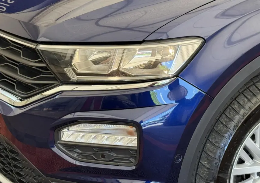 Gros plan sur l'avant droit bleu d'un Volkswagen T-Roc 2.0 TDI 150 IQ.DRIVE avec phares et antibrouillards LED.