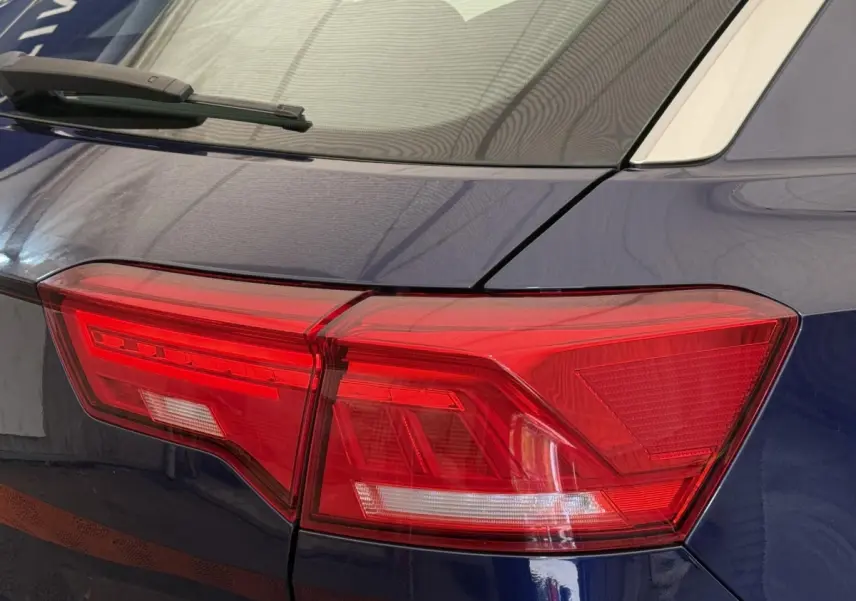Gros plan sur le feu arrière droit rouge d’un Volkswagen T-Roc bleu 2020 avec toit blanc visible.