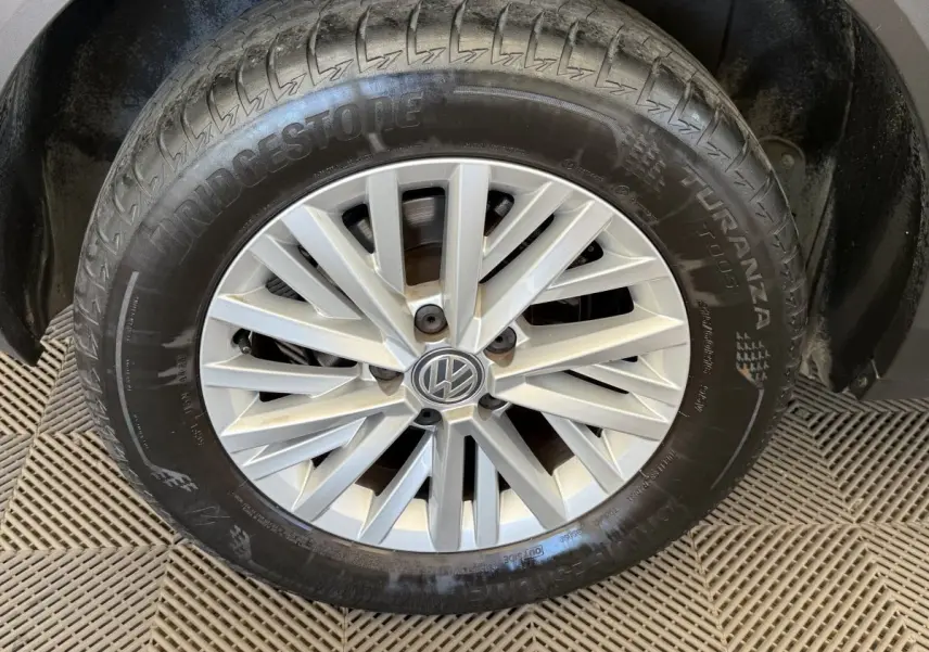 Gros plan sur la roue avant droite d’un Volkswagen T-Roc bleu, avec jante alliage argentée et pneu Bridgestone.